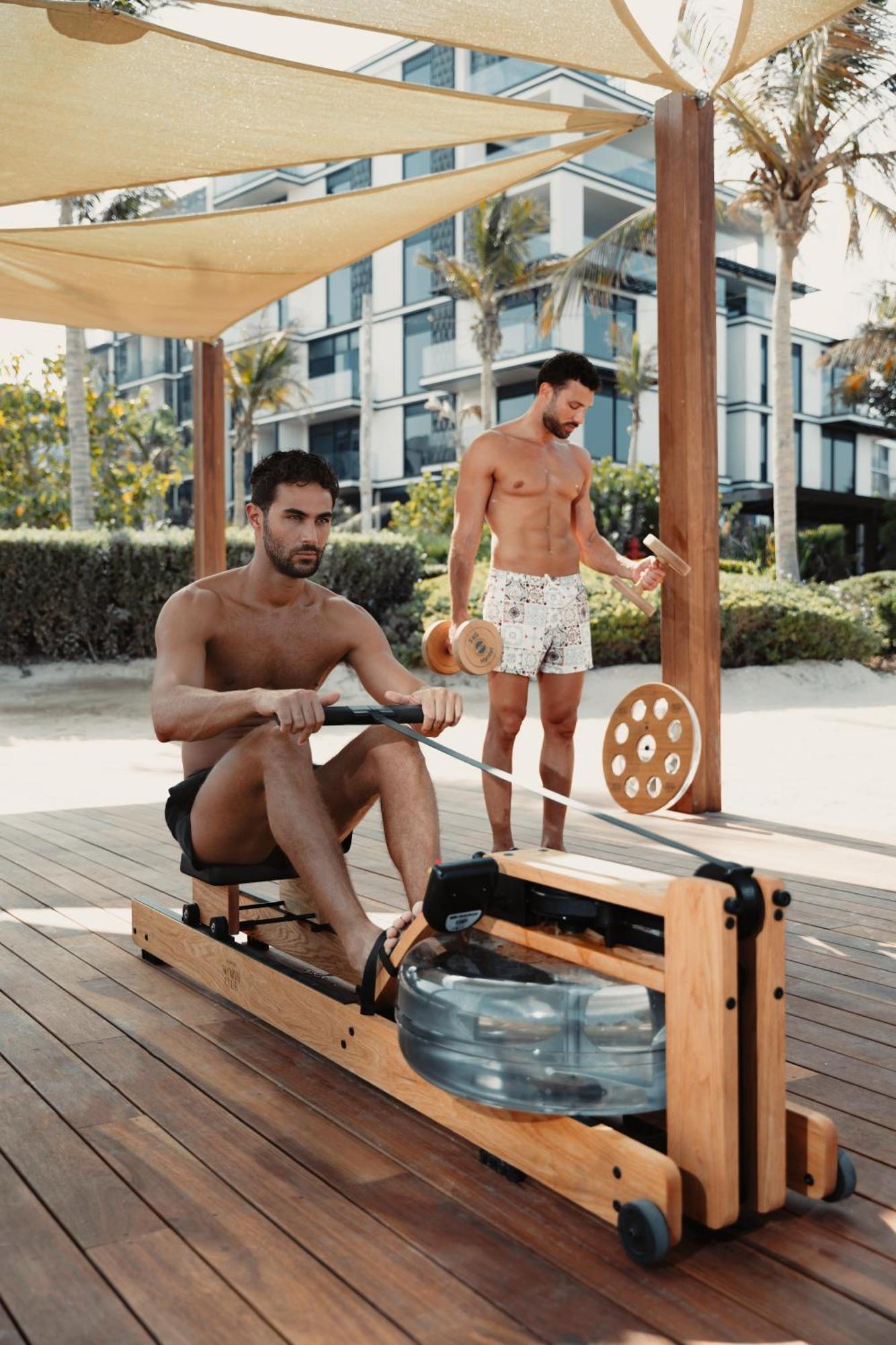 Caesars Palace Dubai Bagian luar foto A man using a water-resistance rowing machine